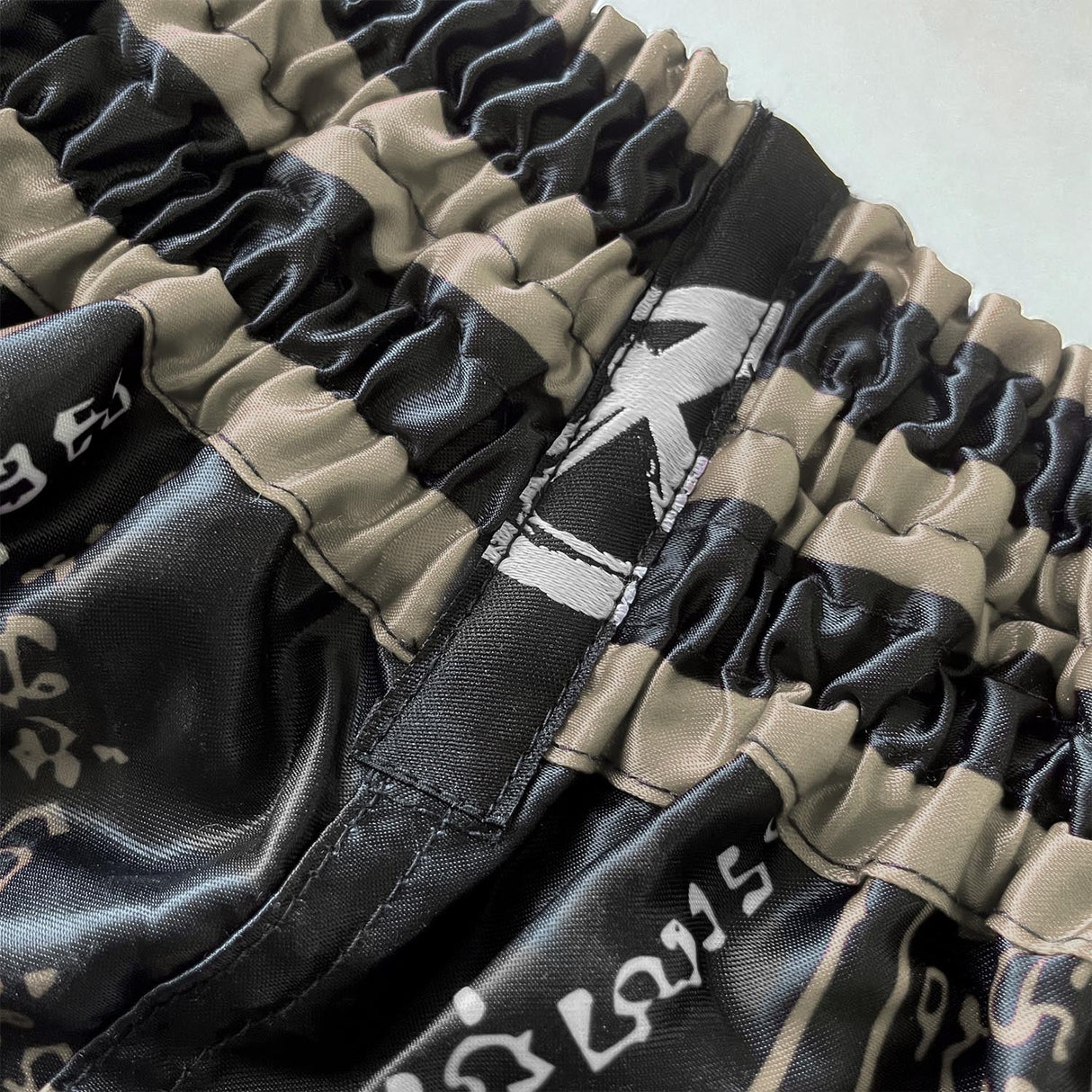 8 WEAPONS Muay-Thai-Shorts 8 Ways Yant 2.0 - Schwarz/Sand