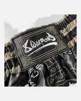 8 WEAPONS Muay-Thai-Shorts 8 Ways Yant 2.0 - Schwarz/Sand